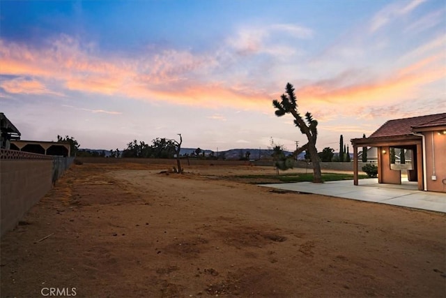 yard at dusk with a patio area