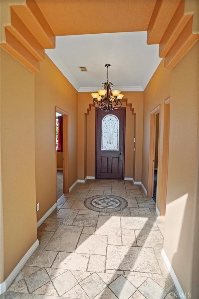 entryway with crown molding and a notable chandelier