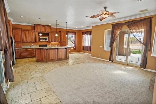 kitchen featuring stainless steel appliances, hanging light fixtures, a healthy amount of sunlight, and a kitchen island with sink