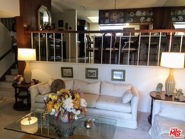 living room with carpet flooring and a chandelier