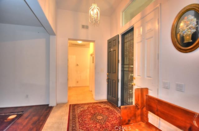 corridor featuring tile patterned floors and an inviting chandelier