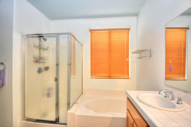 bathroom featuring vanity and shower with separate bathtub