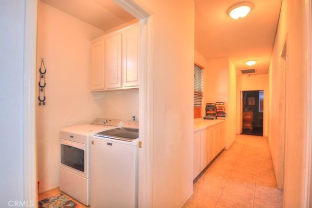 laundry area featuring cabinets, light tile patterned floors, and independent washer and dryer