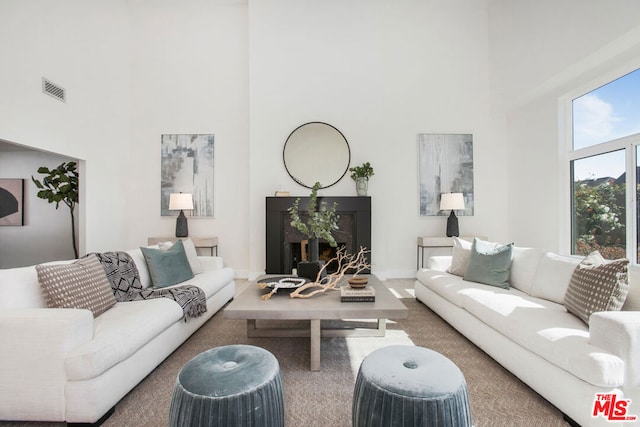 carpeted living room featuring a high ceiling