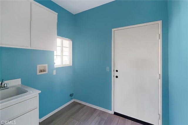 washroom with washer hookup, cabinets, wood-type flooring, and sink