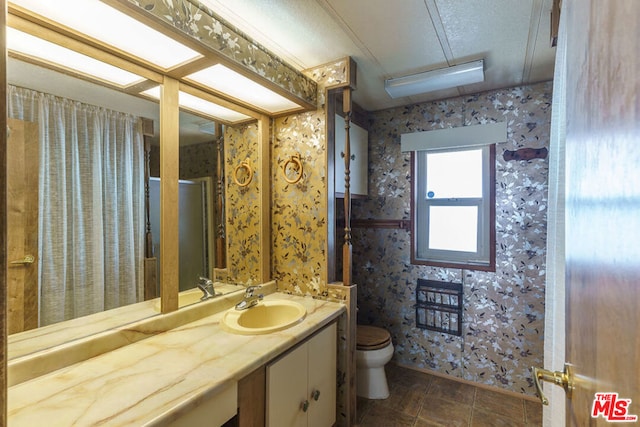 bathroom with tile patterned flooring, vanity, and toilet