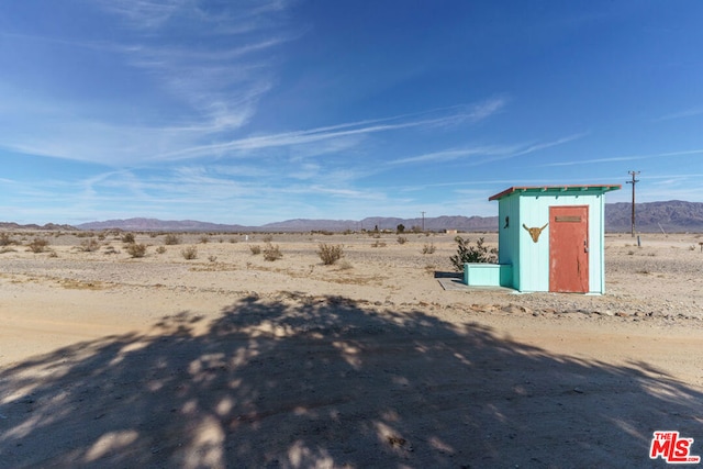 exterior space with a mountain view, a rural view, and a storage unit