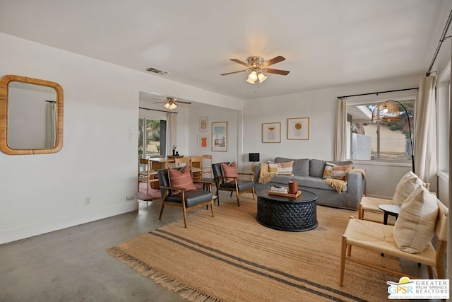 living room with ceiling fan and concrete flooring