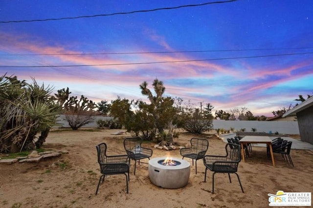 patio terrace at dusk featuring an outdoor fire pit