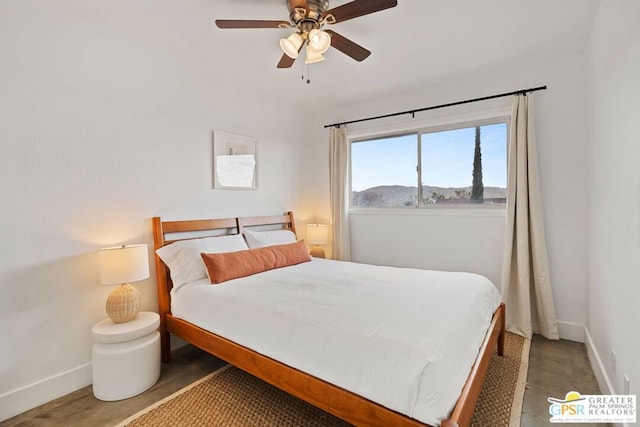 bedroom with ceiling fan and a mountain view