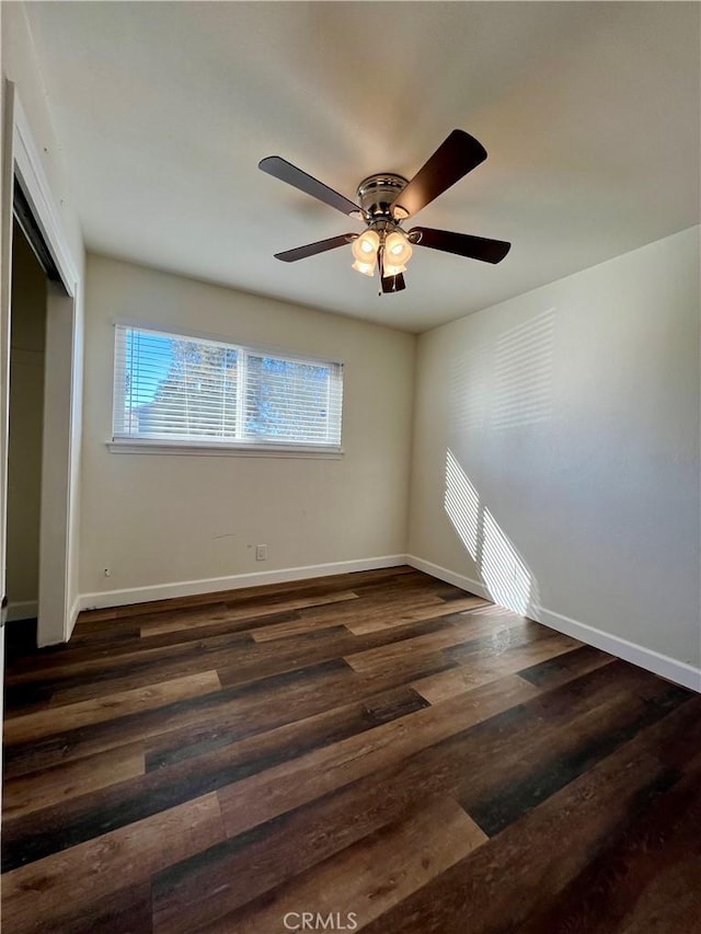 empty room with ceiling fan and dark hardwood / wood-style flooring