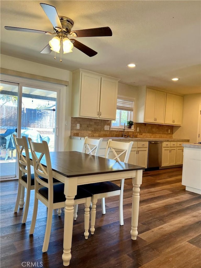 dining room with ceiling fan, sink, and dark wood-type flooring