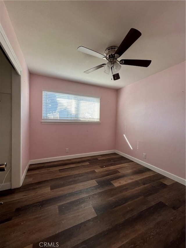 spare room featuring ceiling fan and dark wood-type flooring