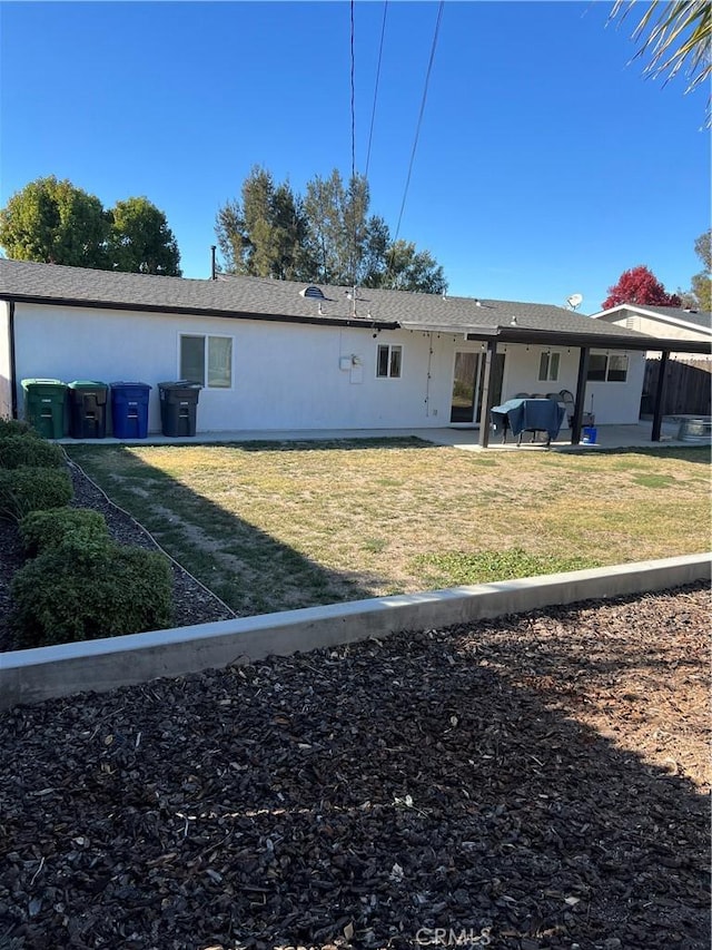 rear view of property featuring a patio area and a lawn