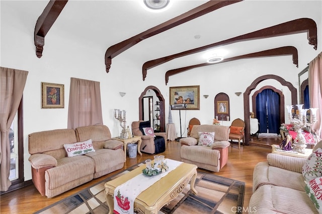 living room featuring lofted ceiling with beams and hardwood / wood-style flooring