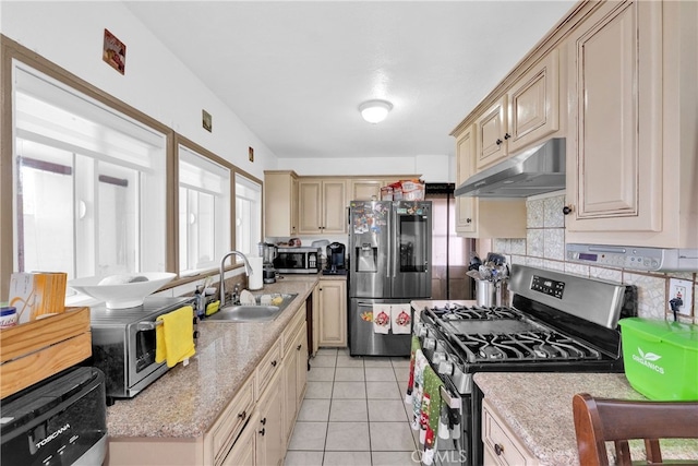 kitchen featuring stainless steel appliances, decorative backsplash, sink, and light tile patterned floors