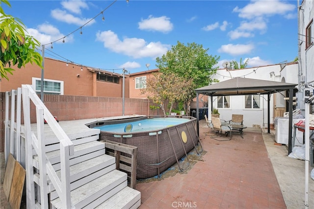 view of patio featuring a fenced in pool and a gazebo