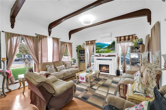 living room featuring light wood-type flooring, a wall mounted air conditioner, and beamed ceiling