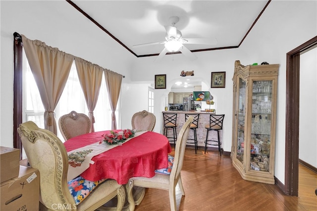 dining room featuring wood-type flooring, ceiling fan, and crown molding