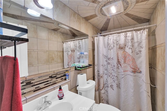 bathroom with toilet, tile walls, lofted ceiling, a shower with shower curtain, and sink