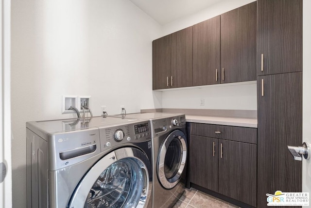 clothes washing area featuring cabinets, light tile patterned flooring, and washing machine and clothes dryer