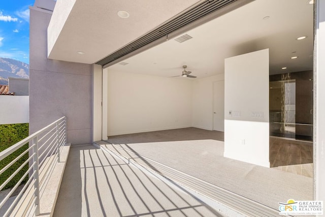 balcony featuring a mountain view and ceiling fan