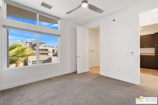 carpeted spare room featuring ceiling fan