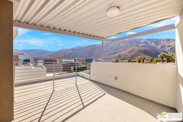 view of patio with a mountain view and a balcony