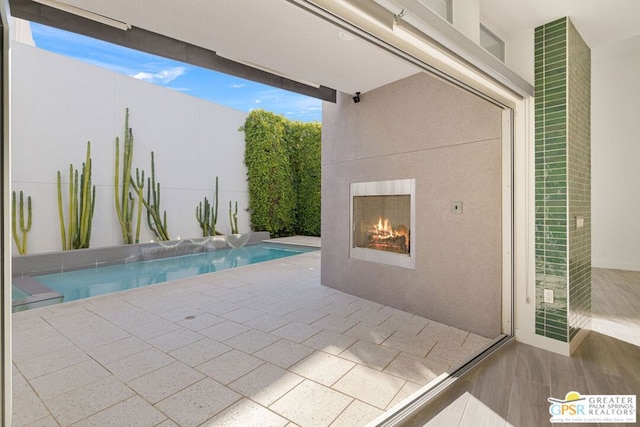 view of swimming pool featuring a patio area and an outdoor fireplace