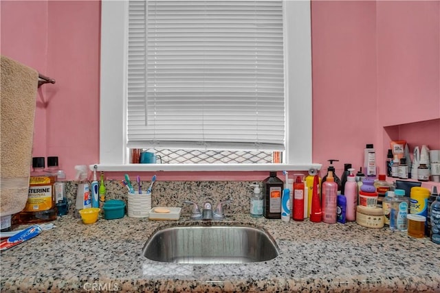 kitchen featuring light stone countertops and sink