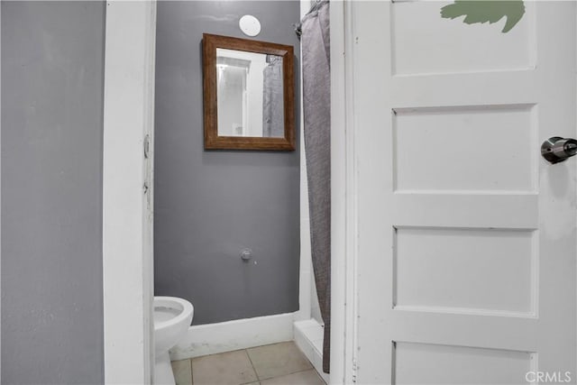 bathroom featuring tile patterned flooring, toilet, and a shower