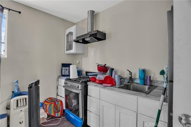 kitchen with white cabinets, wall chimney exhaust hood, sink, and stainless steel appliances