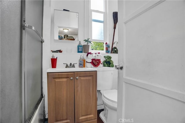 full bathroom with vanity, toilet, and bath / shower combo with glass door