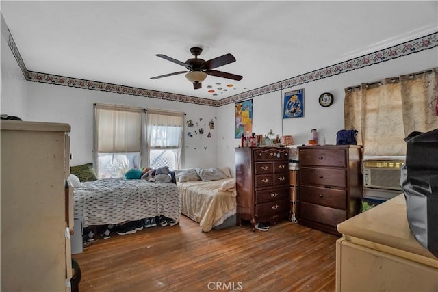 bedroom with hardwood / wood-style flooring, ceiling fan, and cooling unit