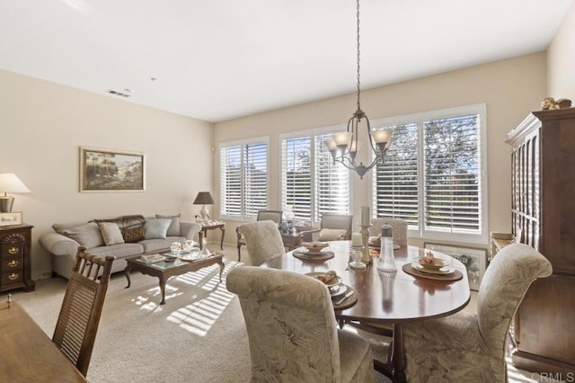 dining area with carpet flooring and a chandelier