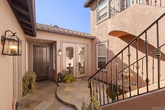 view of exterior entry with french doors and a patio area