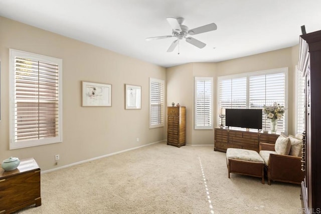 living area with light carpet and ceiling fan