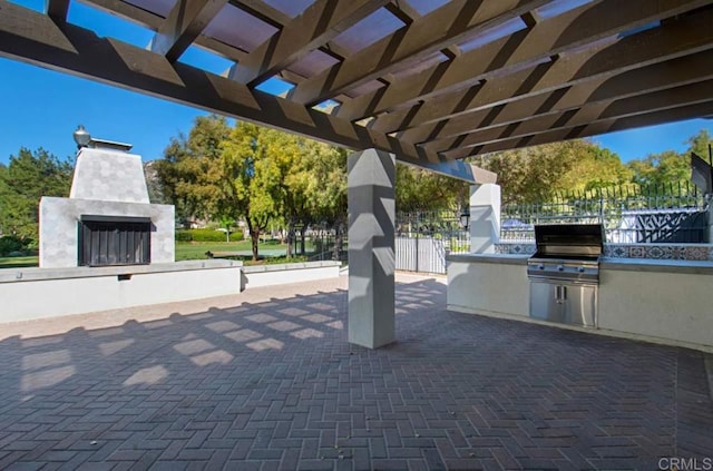 view of patio featuring exterior kitchen, a grill, and a pergola