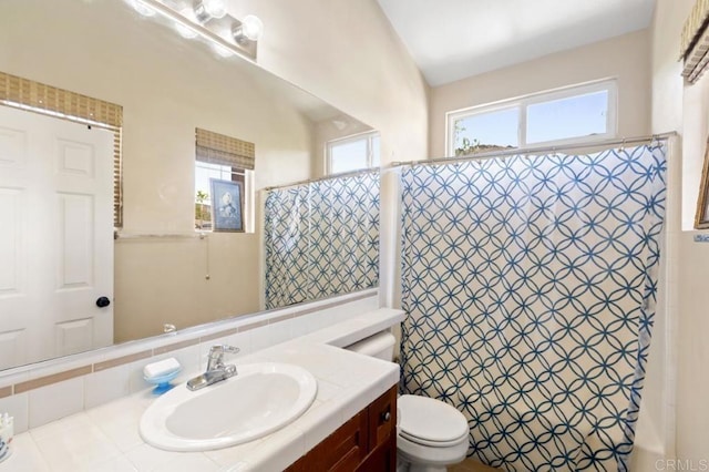 bathroom with vanity, curtained shower, and toilet