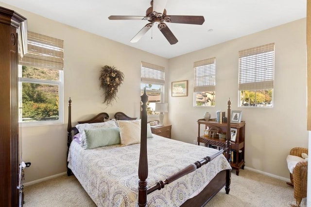 carpeted bedroom with ceiling fan and multiple windows