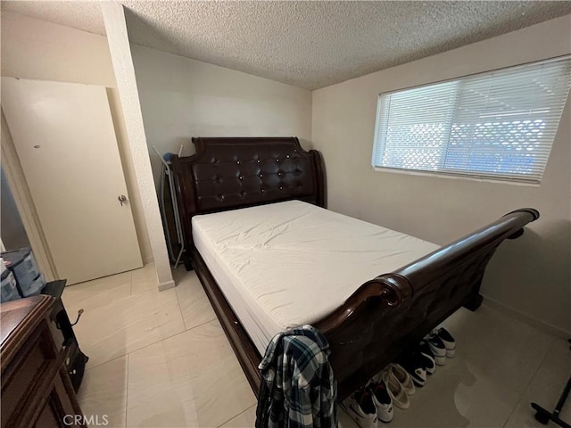 tiled bedroom featuring a textured ceiling