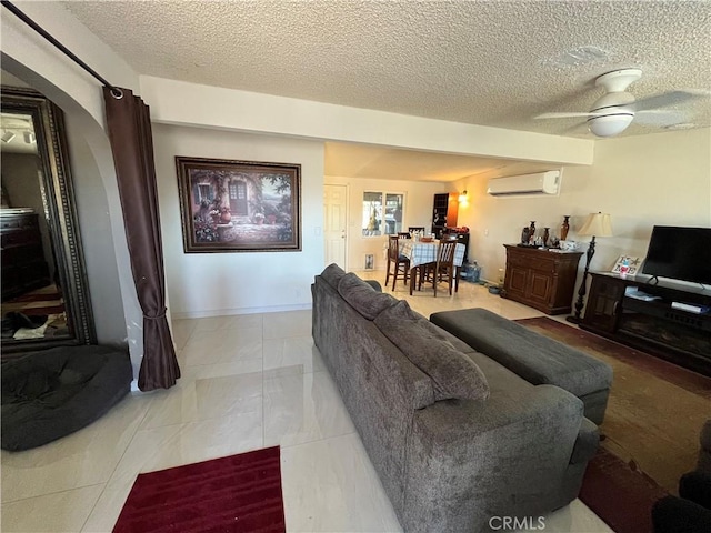 living room with ceiling fan, a textured ceiling, light tile patterned floors, and a wall unit AC