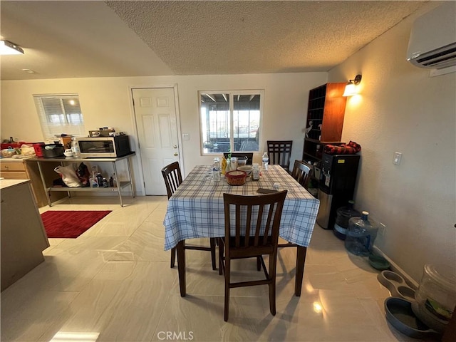 dining area with a textured ceiling and a wall mounted AC