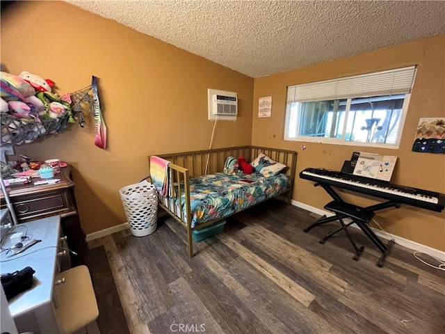 bedroom featuring a textured ceiling, dark hardwood / wood-style floors, and a wall mounted air conditioner