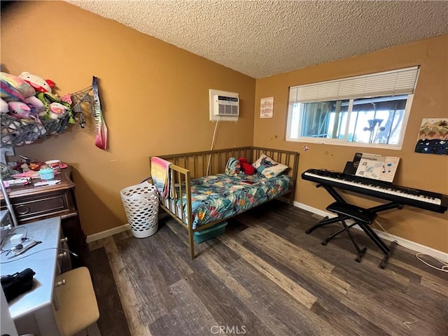 bedroom with wood finished floors, baseboards, an AC wall unit, a textured ceiling, and vaulted ceiling