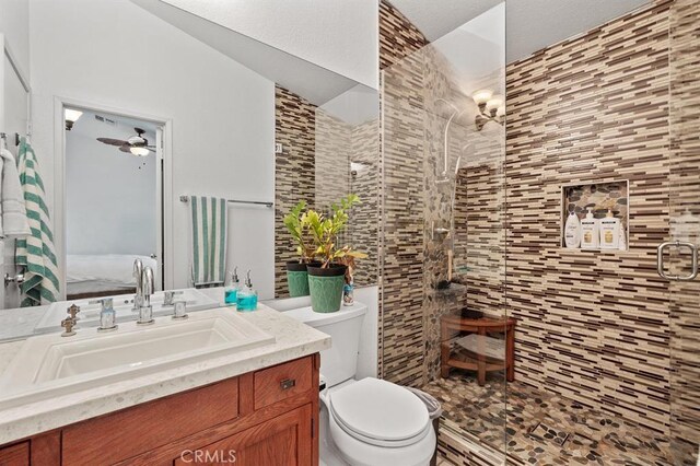 bathroom with walk in shower, vanity, ceiling fan, toilet, and lofted ceiling