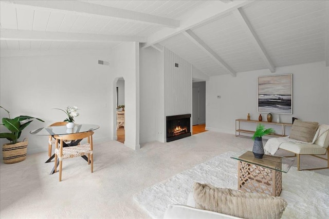 carpeted living room with beam ceiling, a fireplace, and high vaulted ceiling