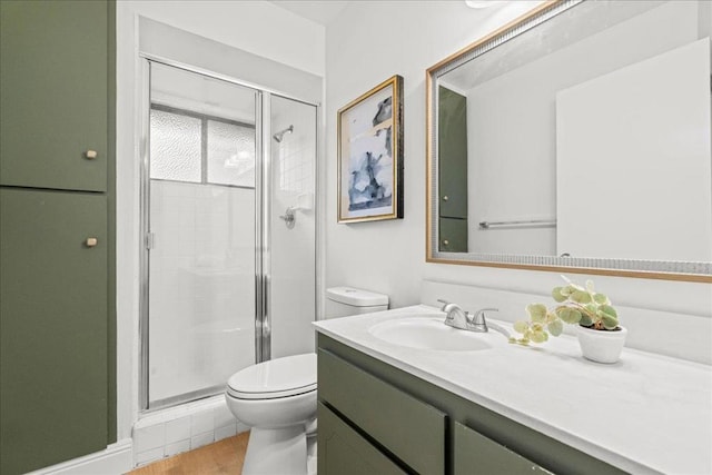 bathroom with hardwood / wood-style flooring, toilet, vanity, and walk in shower