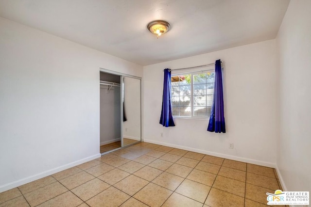 unfurnished bedroom featuring a closet and light tile patterned floors