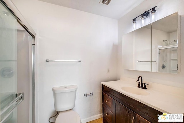 bathroom with vanity, toilet, and an enclosed shower